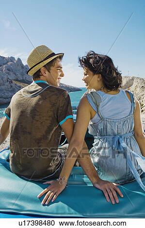 Man and woman sitting on car. View Large Photo Image Stock Image - Man and woman sitting on car.. Fotosearch
