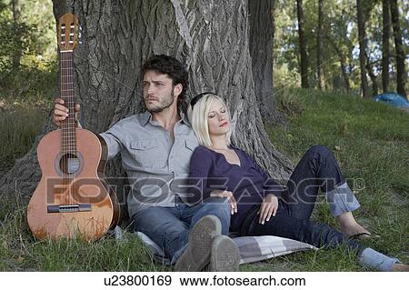 Man holding a guitar with sleeping woman leaning on him. View Large Photo Image Stock Photo - Man holding a guitar with sleeping woman leaning on him.. Fotosearch