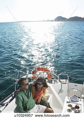 Mature couple relaxing on yacht, smiling, overhead view View Large Photo Image Stock Photo - Mature couple relaxing on yacht, smiling, overhead view. Fotosearch