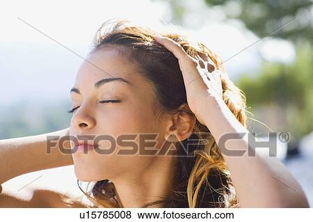 Stock Photo - Woman outdoors with hands on head.. Fotosearch