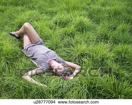 Woman relaxing in a green field. View Large Photo Image Picture - Woman relaxing in a green field.. Fotosearch