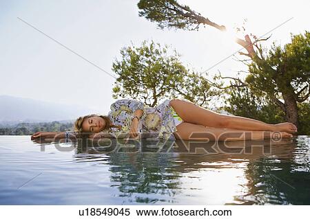 Stock Photography - Young woman by poolside.. Fotosearch