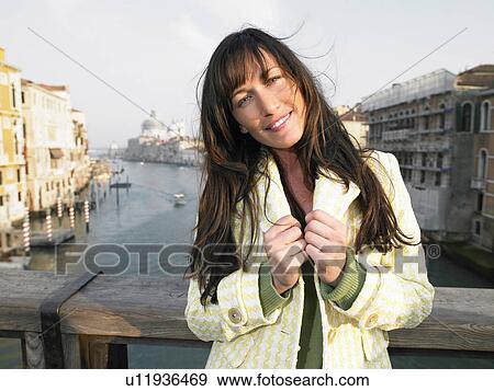 Stock Photo - Portrait of woman on Academia Bridge overlooking Grand Canal. Venice, Italy.. Fotosearch