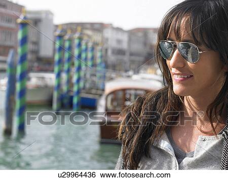 Stock Photograph - Portrait of woman wearing sunglasses. Rialto, Venice, Italy.. Fotosearch