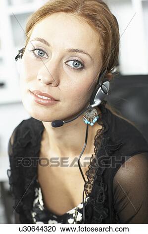 Woman smiling on headset View Large Photo Image Stock Image - Woman smiling on headset. Fotosearch