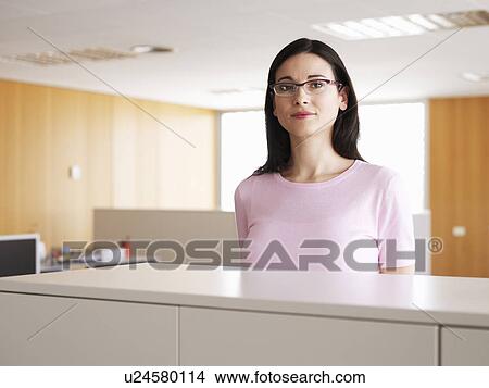 Young businesswoman standing in office, portrait View Large Photo Image Picture - Young businesswoman standing in office, portrait. Fotosearch
