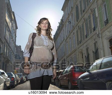 Young pregnant woman standing in street, portrait View Large Photo Image Picture - Young pregnant woman standing in street, portrait. Fotosearch