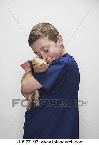 Stock Photo - Boy hugging piglet. Fotosearch