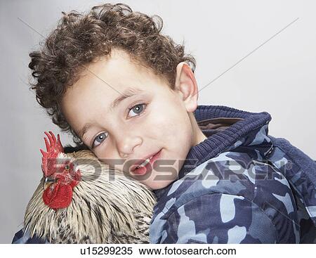Stock Photography - Close up of boy and cockerel. Fotosearch