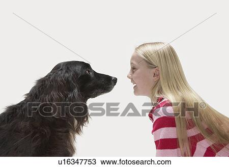 Stock Image - Portrait of girl looking at dog. Fotosearch