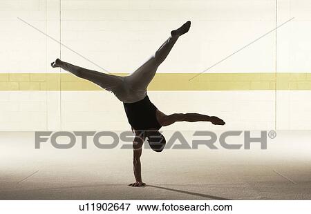 Male gymnast balancing on one hand, rear view View Large Photo Image Stock Photo - Male gymnast balancing on one hand, rear view. Fotosearch