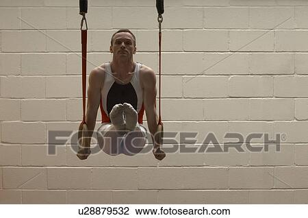 Male gymnast balancing on rings View Large Photo Image Stock Image - Male gymnast balancing on rings. Fotosearch
