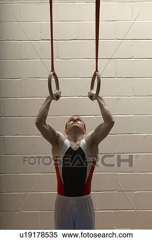 Male gymnast hanging from rings, looking up View Large Photo Image Stock Photography - Male gymnast hanging from rings, looking up. Fotosearch
