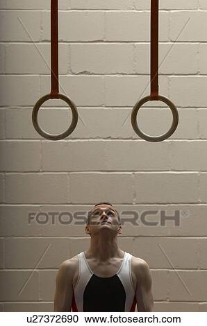 Male gymnast looking up at rings in gymnasium View Large Photo Image Stock Image - Male gymnast looking up at rings in gymnasium. Fotosearch