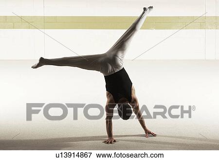 Male gymnast performing floor exercise, rear view View Large Photo Image Stock Photo - Male gymnast performing floor exercise, rear view. Fotosearch