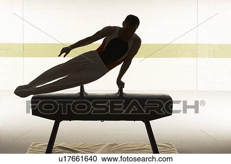 Male gymnast performing on pommel horse View Large Photo Image Stock Image - Male gymnast performing on pommel horse. Fotosearch
