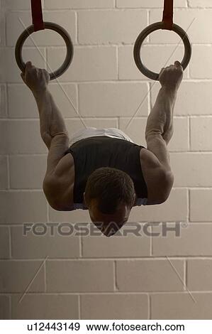 Male gymnast performing on rings View Large Photo Image Stock Photo - Male gymnast performing on rings. Fotosearch