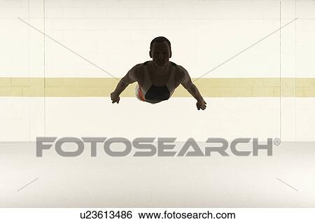 Stock Photograph - Male gymnast performing somersault in floor exercise. Fotosearch