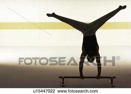 Male gymnast practising on floor bar, rear view View Large Photo Image Stock Image - Male gymnast practising on floor bar, rear view. Fotosearch