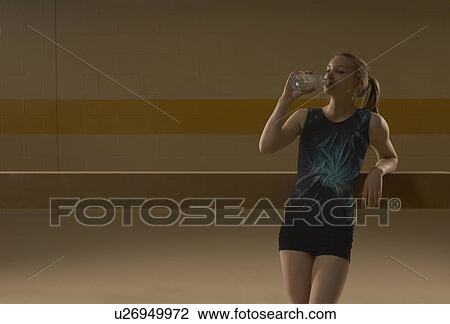 Teenage gymnast (16-18) drinking water, leaning on balance beam View Large Photo Image Stock Image - Teenage gymnast (16-18) drinking water, leaning on balance beam. Fotosearch