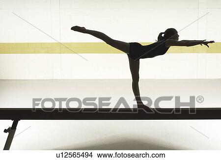 Teenage gymnast (16-18) performing on balance beam View Large Photo Image Picture - Teenage gymnast (16-18) performing on balance beam. Fotosearch
