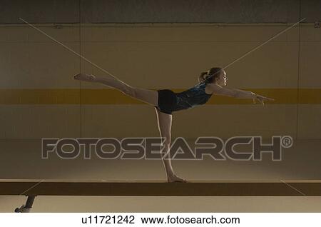 Teenage gymnast (16-18) performing on balance beam View Large Photo Image Stock Image - Teenage gymnast (16-18) performing on balance beam. Fotosearch