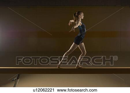 Teenage gymnast (16-18) performing on balance beam View Large Photo Image Stock Image - Teenage gymnast (16-18) performing on balance beam. Fotosearch