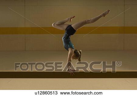 Teenage gymnast (16-18) performing on balance beam View Large Photo Image Stock Image - Teenage gymnast (16-18) performing on balance beam. Fotosearch