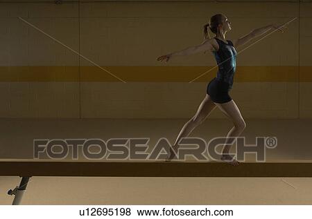 Teenage gymnast (16-18) performing on balance beam View Large Photo Image Stock Photo - Teenage gymnast (16-18) performing on balance beam. Fotosearch