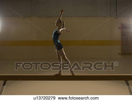 Teenage gymnast (16-18) performing on balance beam View Large Photo Image Stock Photo - Teenage gymnast (16-18) performing on balance beam. Fotosearch