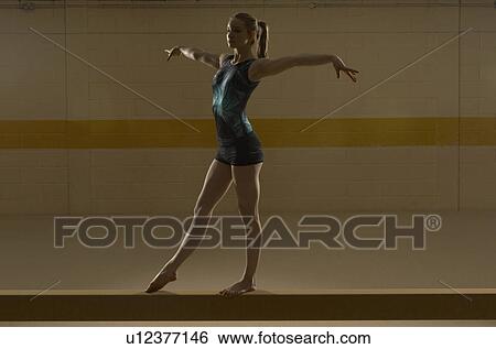 Teenage gymnast (16-18) performing on balance beam View Large Photo Image Stock Photograph - Teenage gymnast (16-18) performing on balance beam. Fotosearch