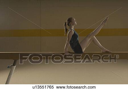Stock Photography - Teenage gymnast (16-18) performing on balance beam. Fotosearch