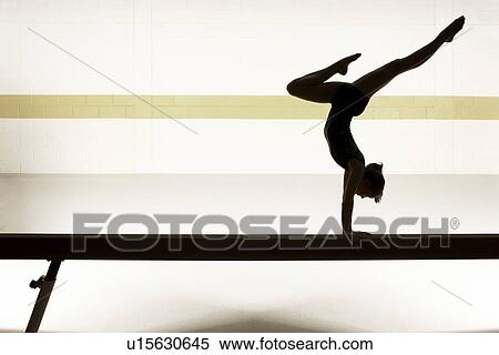 Teenage gymnast (16-18) performing on balance beam View Large Photo Image Stock Photography - Teenage gymnast (16-18) performing on balance beam. Fotosearch
