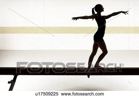 Stock Photography - Teenage gymnast (16-18) performing on balance beam. Fotosearch
