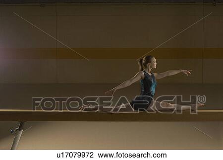 Teenage gymnast (16-18) performing splits on balance beam View Large Photo Image Stock Image - Teenage gymnast (16-18) performing splits on balance beam. Fotosearch