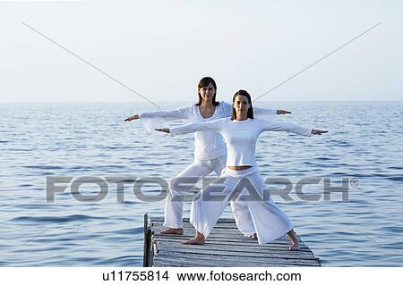 Two women on dock doing yoga. View Large Photo Image Picture - Two women on dock doing yoga.. Fotosearch