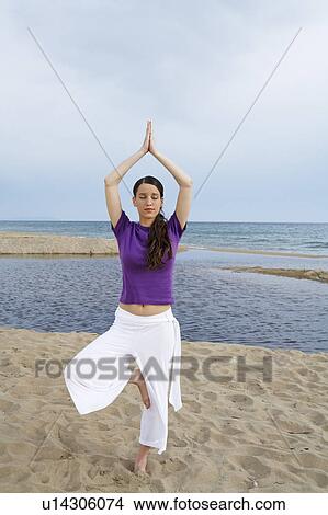 Woman doing yoga on beach with eyes closed. View Large Photo Image Picture - Woman doing yoga on beach with eyes closed.. Fotosearch