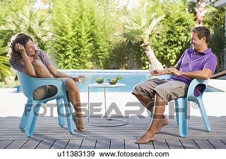 Couple on a wooden terrace by a pool View Large Photo Image Stock Photo - Couple on a wooden terrace by a pool. Fotosearch