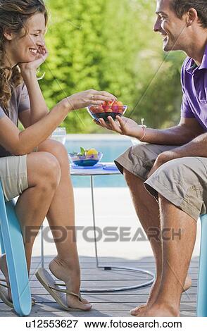 Couple on a wooden terrace by a pool View Large Photo Image Stock Photo - Couple on a wooden terrace by a pool. Fotosearch