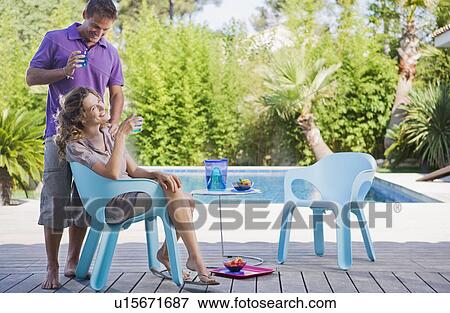 Couple on a wooden terrace by a pool View Large Photo Image Stock Photo - Couple on a wooden terrace by a pool. Fotosearch