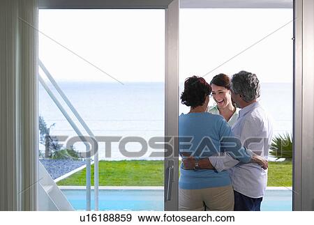 Family standing in door way embracing View Large Photo Image Stock Photo - Family standing in door way embracing. Fotosearch