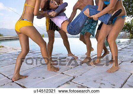 Men and women throw a friend into a pool View Large Photo Image Stock Image - Men and women throw a friend into a pool. Fotosearch