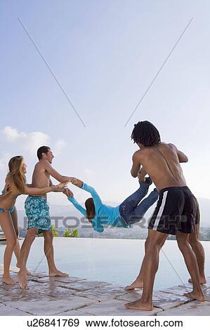 Men and women throw a friend into a pool View Large Photo Image Stock Photo - Men and women throw a friend into a pool. Fotosearch