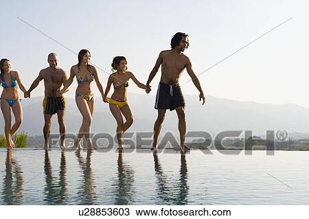 People walking by a pool, holding hands View Large Photo Image Stock Image - People walking by a pool, holding hands. Fotosearch