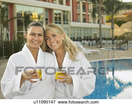 Two women by hotel pool with juice View Large Photo Image Stock Photo - Two women by hotel pool with juice . Fotosearch