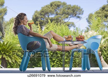 Woman on a wooden terrace by a pool View Large Photo Image Stock Photo - Woman on a wooden terrace by a pool. Fotosearch