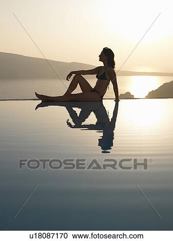 Woman sitting on the edge of a pool View Large Photo Image Stock Image - Woman sitting on the edge of a pool. Fotosearch