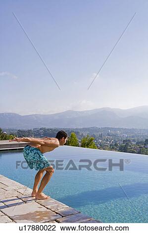 Stock Image - Young man diving into a pool. Fotosearch