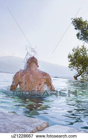 Young man splashing in a pool View Large Photo Image Stock Photo - Young man splashing in a pool. Fotosearch