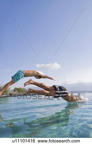 Young men diving into a pool View Large Photo Image Stock Photograph - Young men diving into a pool. Fotosearch